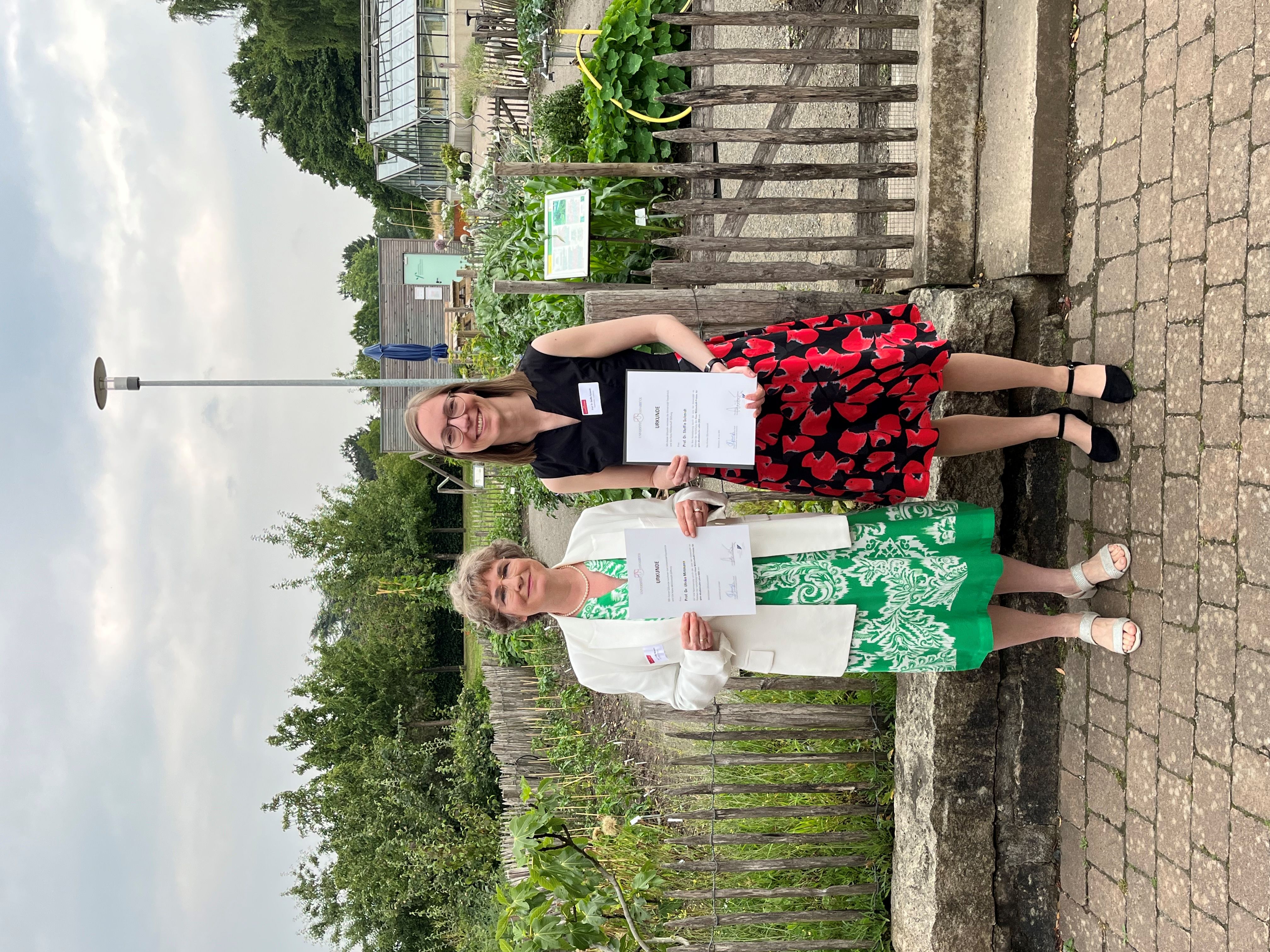 Prof. Dr. Ulrike Mittmann (links im Bild) und Prof. Dr. Steffie Schmidt (rechts im Bild) stehen im Botanischen Garten der Uni Osnabrück bei der Preisverleihung zum Hans Mühlenhoff-Preis 2025